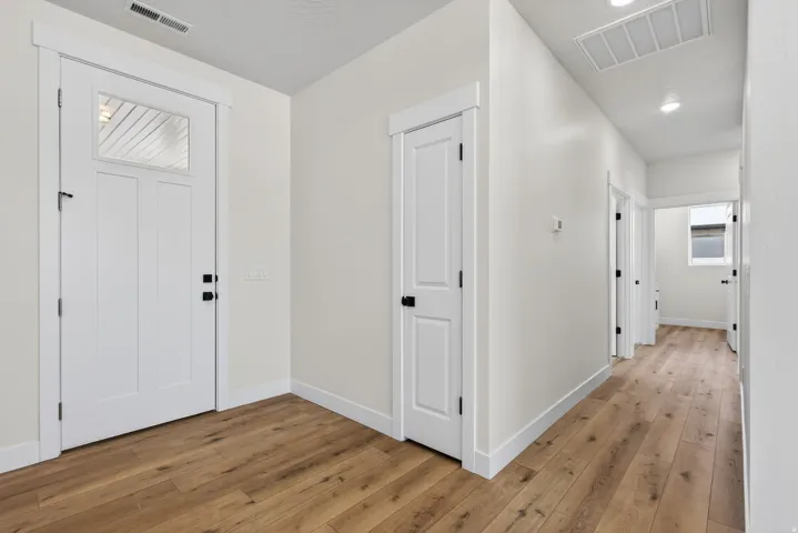 Entryway featuring a white paneled door with glass insert, wood-finish flooring, recessed lighting, and white trim
