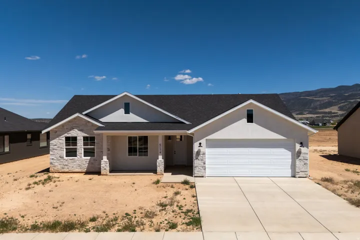 Contemporary ranch-style residence featuring a prominent two-car garage with a white panel door