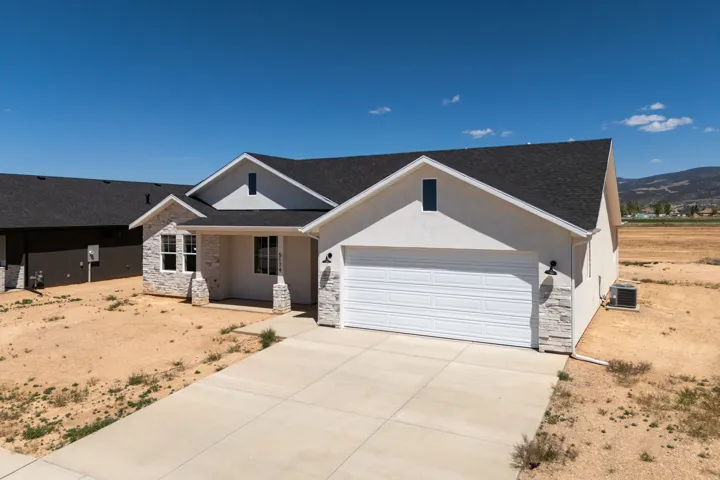 Contemporary single-story residence featuring a two-car garage, stone veneer accents, and a covered front porch