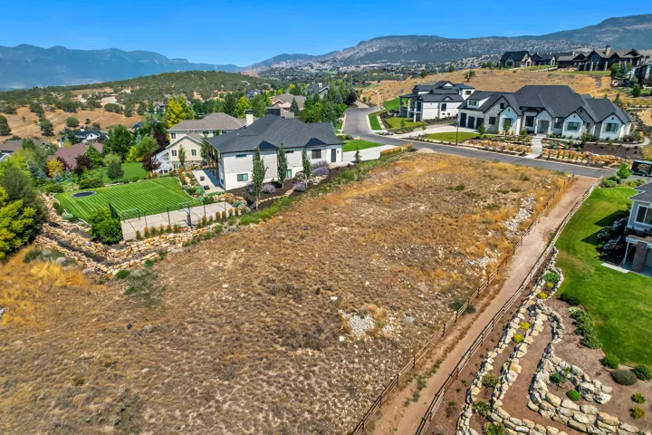 Expansive vacant lot with professional grading and hardscape edging, situated in a hillside community with mountain backdrop - views looking towards the northwest