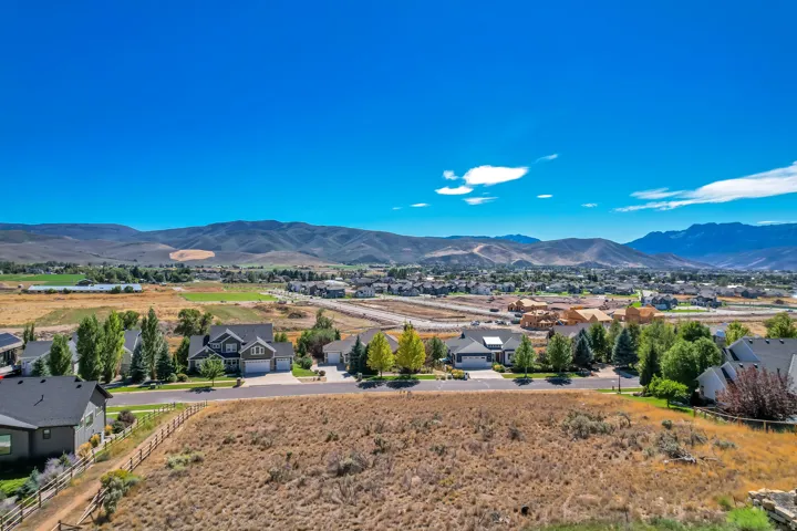 Expansive residential area featuring established homes, developing construction, and a clear mountain backdrop
