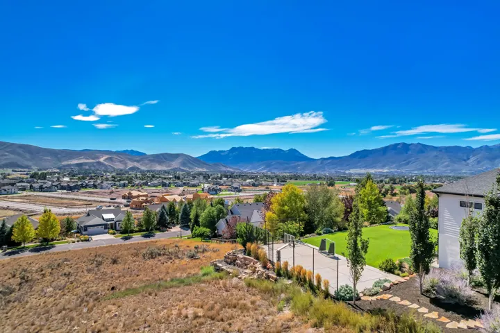 Expansive grounds featuring a basketball court, manicured lawn, and established trees
