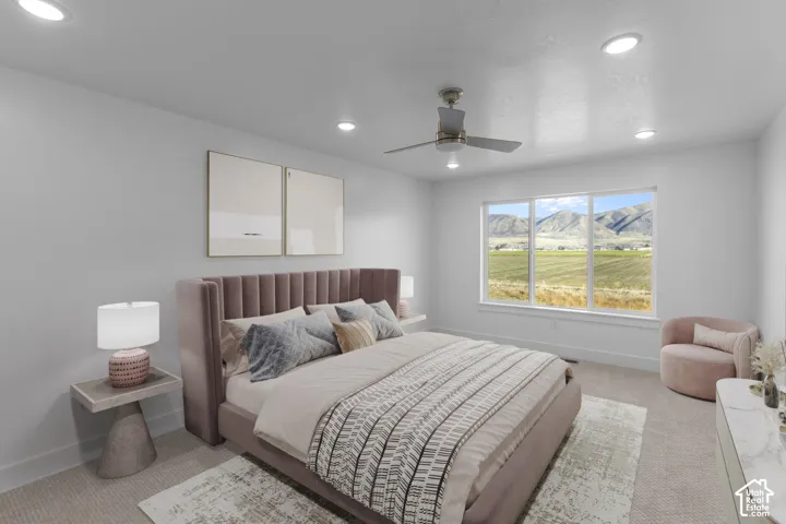 Spacious primary bedroom featuring a tufted upholstered headboard in mauve, recessed ceiling lighting, and a ceiling fan