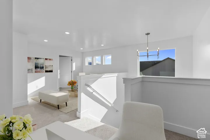 Modern open-concept living space featuring clean white walls, recessed ceiling lighting, and abundant natural light from multiple windows