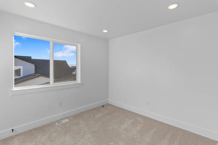 Neutral tone carpeting, white baseboards, and recessed lighting fixtures