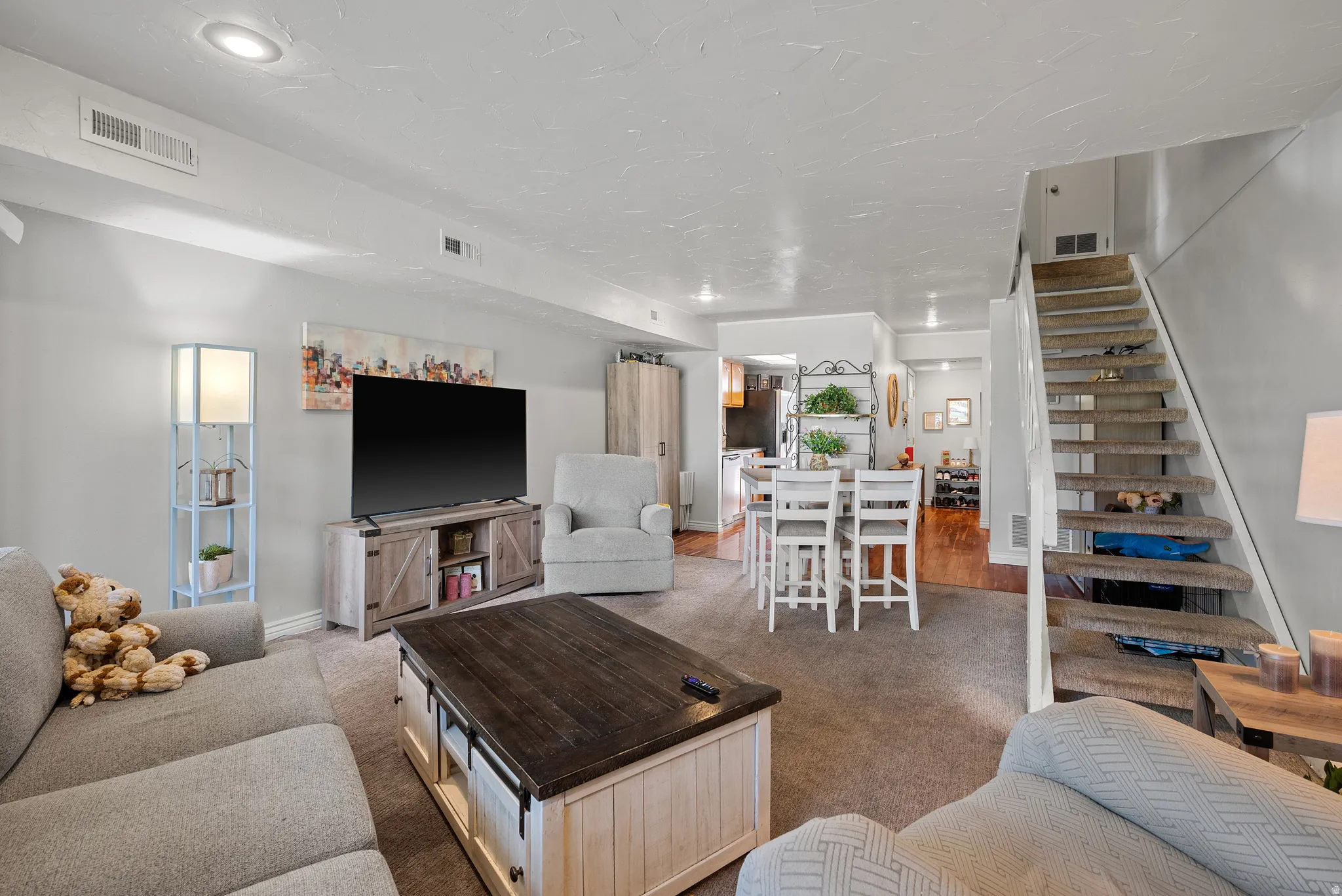 Carpeted living area with light gray walls and recessed lighting