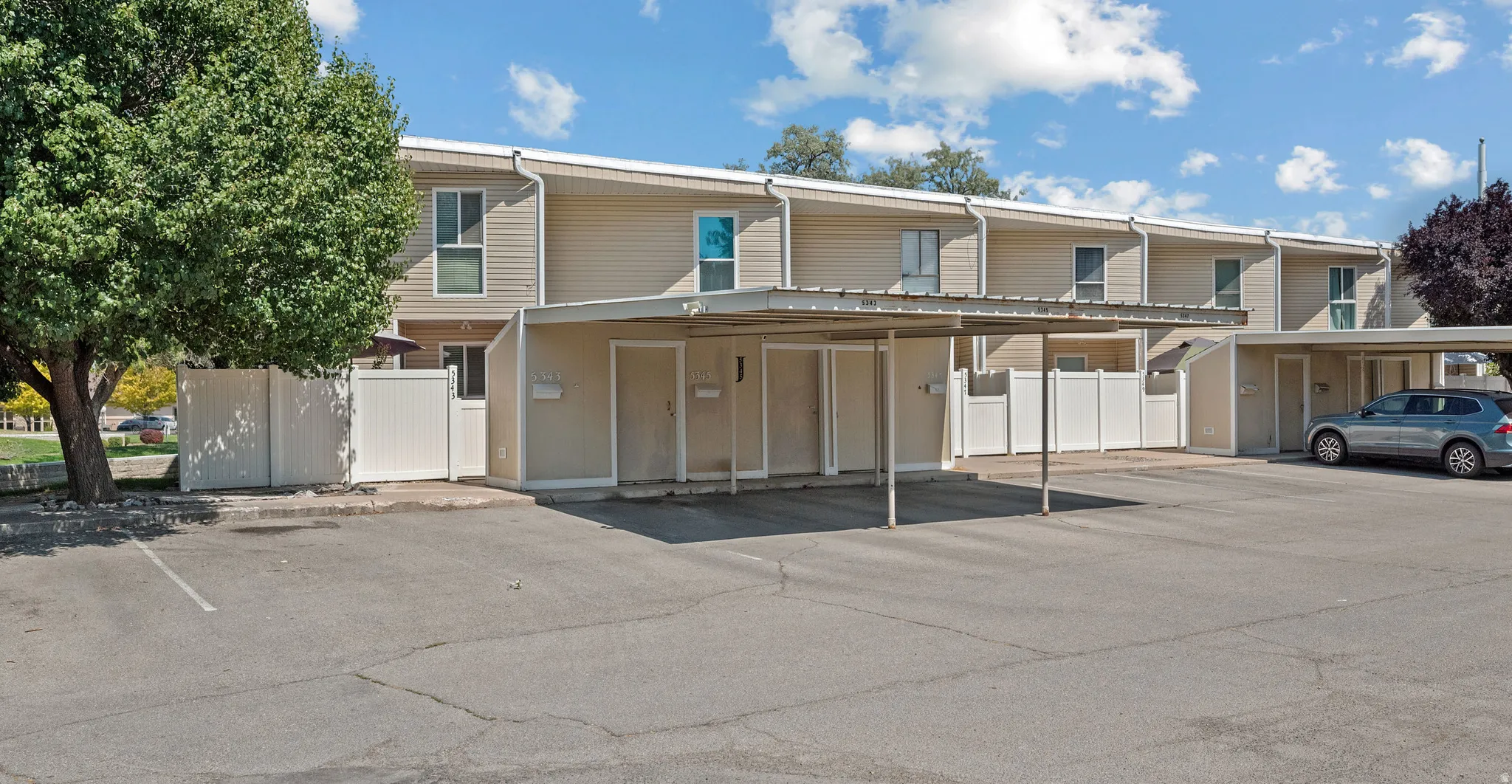 Multi-unit building featuring tan siding and white trim