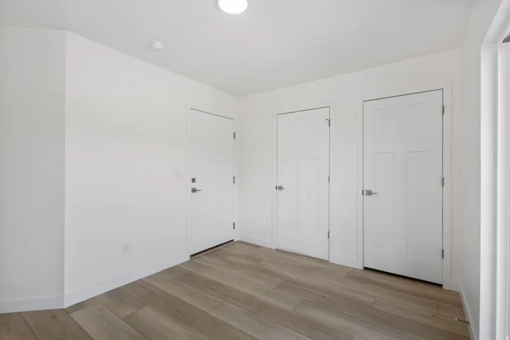 Entryway featuring wood-finish flooring, white baseboards, and bright white walls
