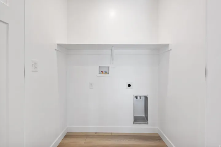 Dedicated laundry area with light wood-finish flooring