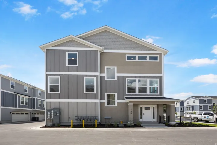 Contemporary multi-story residence featuring a varied facade with vertical siding and stucco finishes