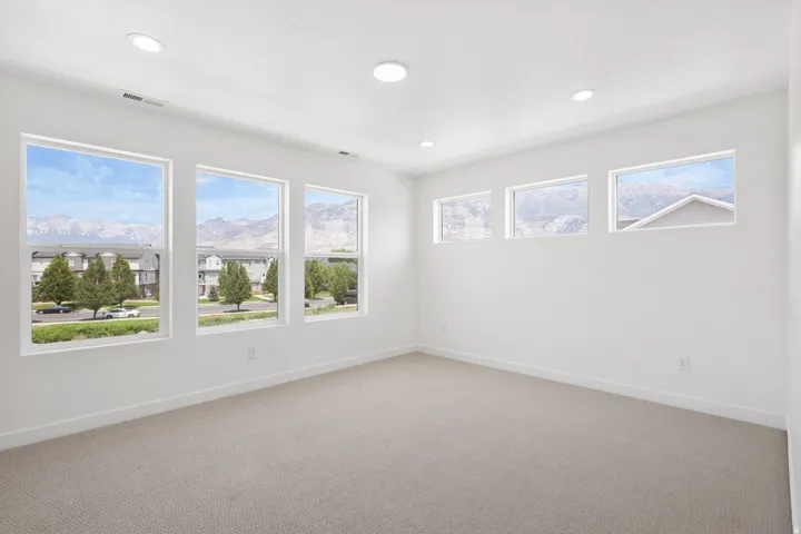 Spacious room featuring multiple large windows offering mountain scenery