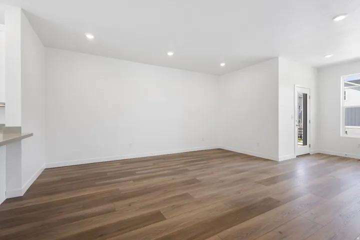 Spacious interior featuring wood-finish flooring, recessed lighting, and white baseboards