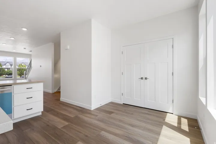 Open concept living space featuring wood-finish flooring, white walls, and recessed lighting