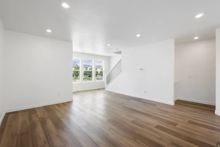 Open-concept living area featuring wood-finish flooring, recessed lighting, and white baseboards