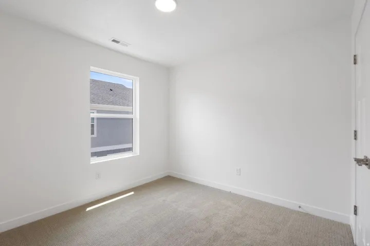 Room featuring neutral wall finishes and light-toned carpeting