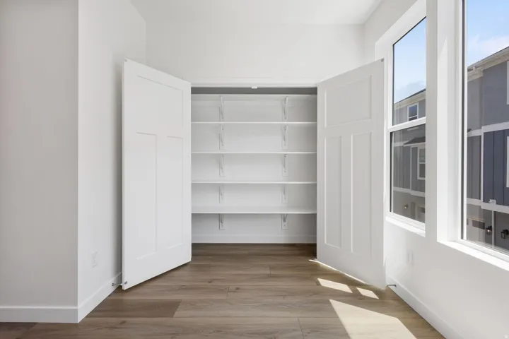 Wardrobe closet featuring bi-fold panel doors and adjustable shelving