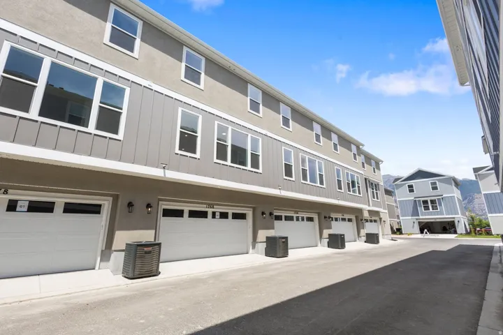 Modern townhouse exterior featuring a neutral gray stucco and vertical siding facade