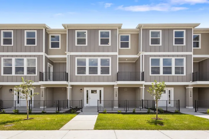 Modern townhome row featuring a neutral gray and beige facade with vertical siding accents