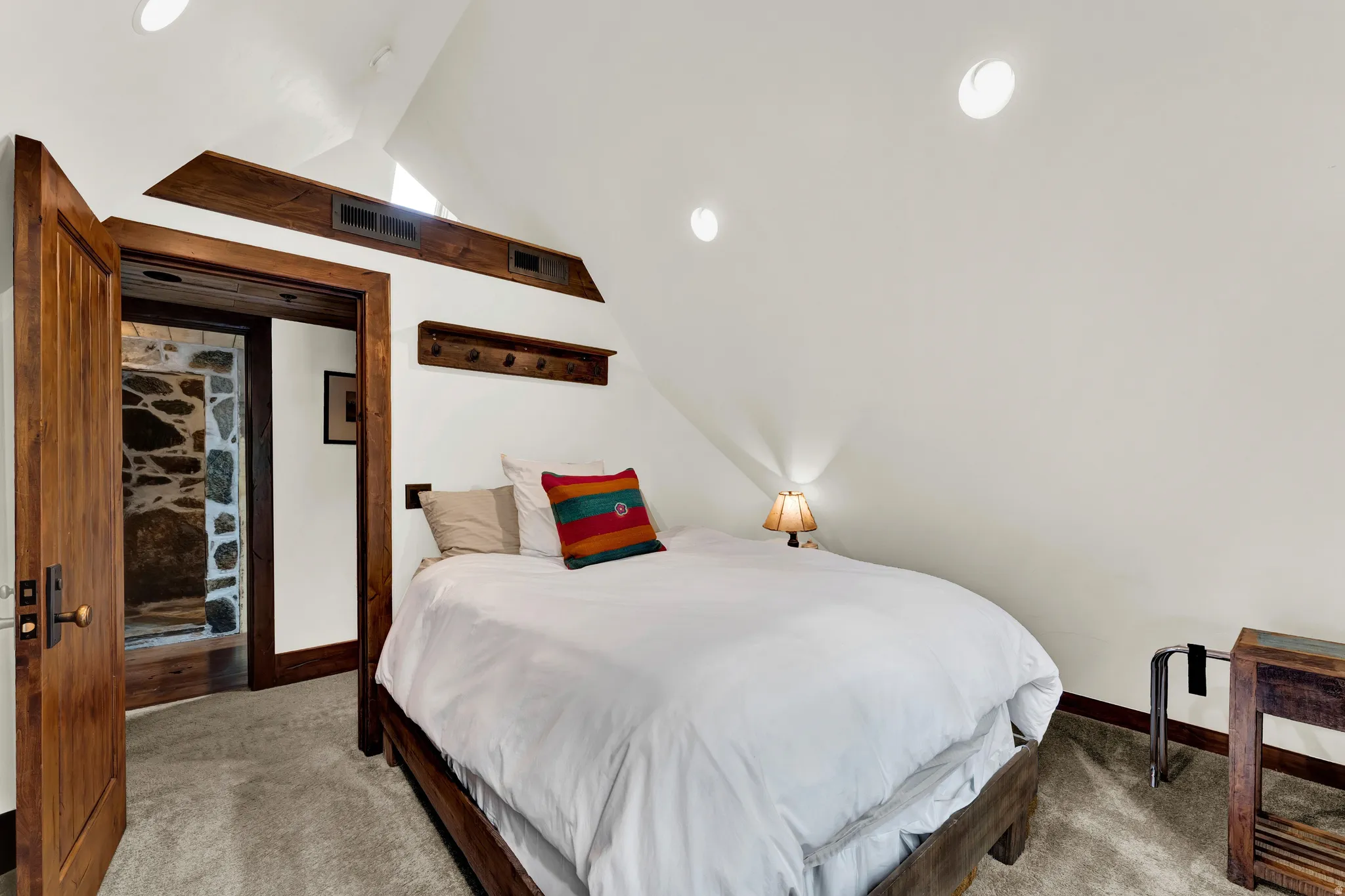 Vaulted ceiling room with recessed lighting and warm wood trim