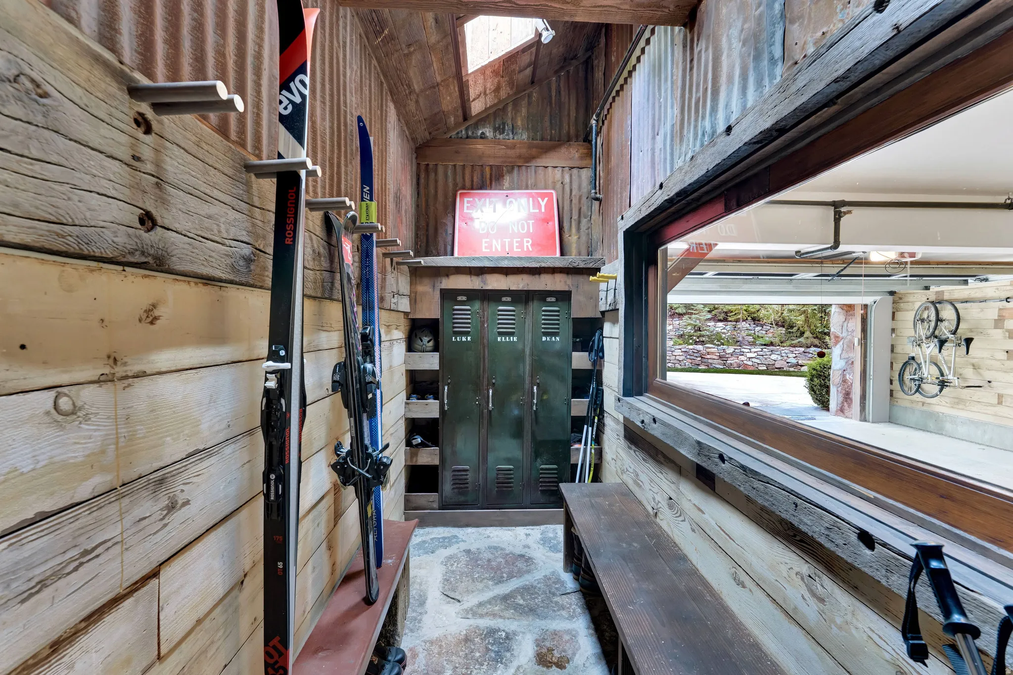 Unique converted shipping container featuring industrial-style interior with corrugated metal walls, wooden horizontal paneling, and custom built-in shelving throughout