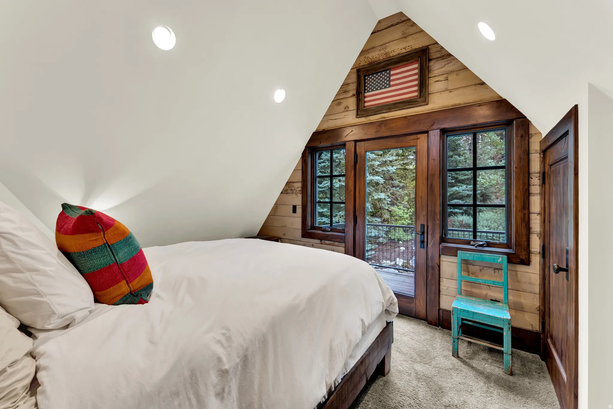 Charming bedroom retreat featuring a pitched wood-beam ceiling with integrated skylight, recessed lighting, and an abundance of natural illumination