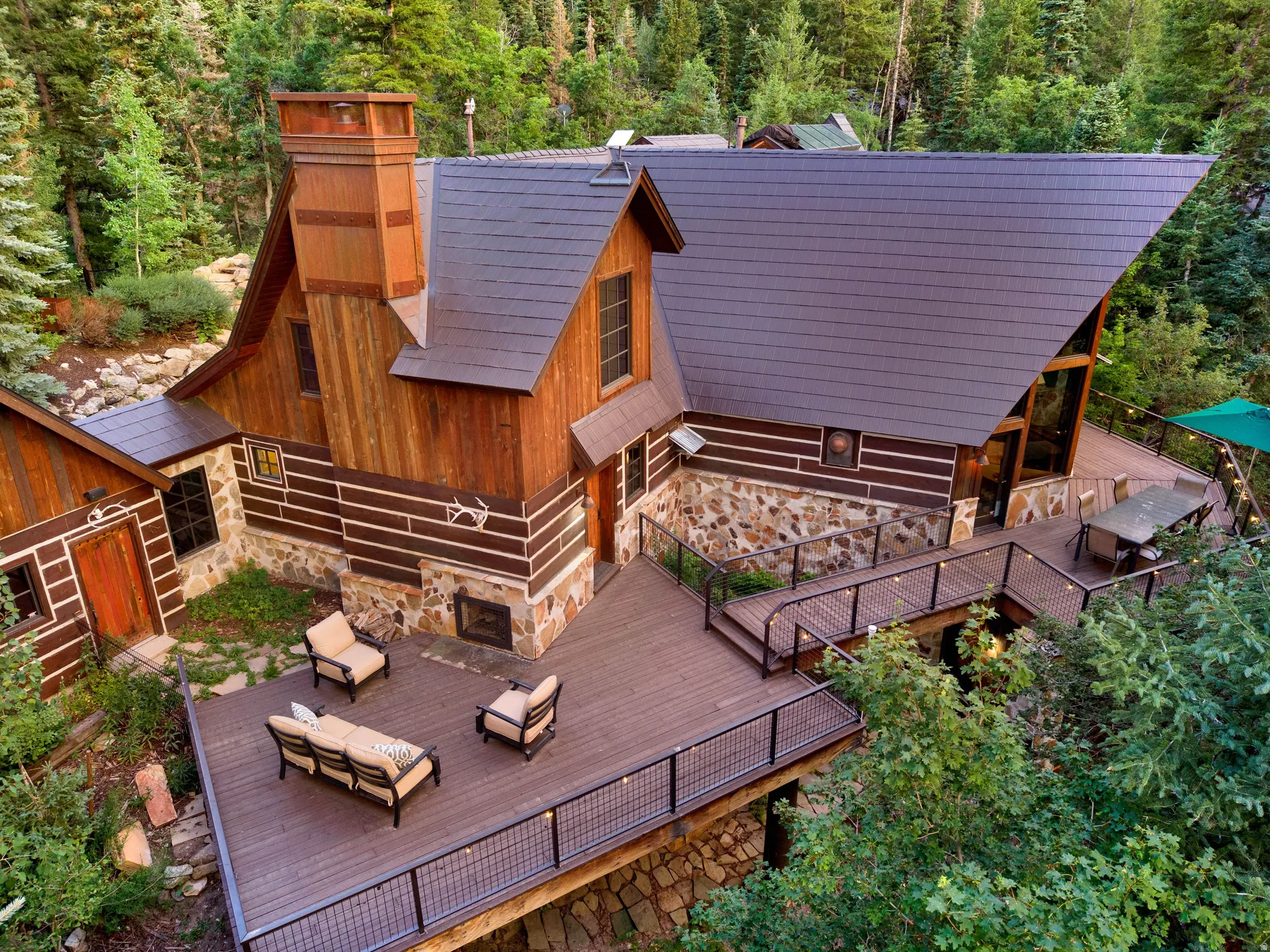 Stunning mountain retreat featuring a wood-and-stone contemporary design with steep pitched rooflines and large picture windows