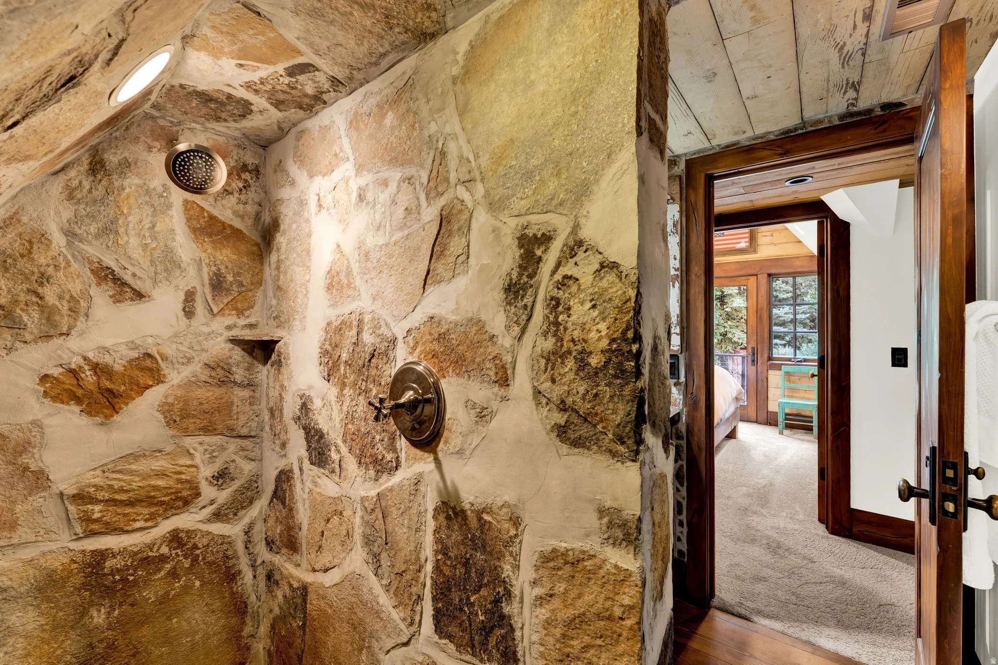 Rustic stone accent wall featuring natural earth-toned masonry with bronze hardware fixtures