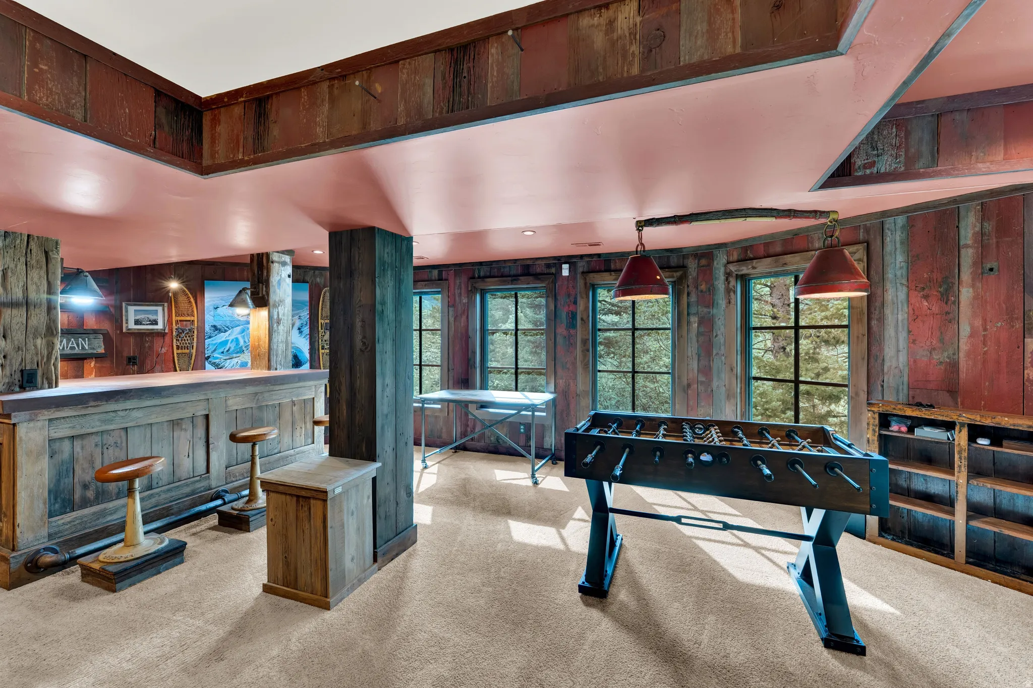 Recreation room showcasing soaring ceilings with skylights, rich wood-finish paneling, and polished concrete flooring