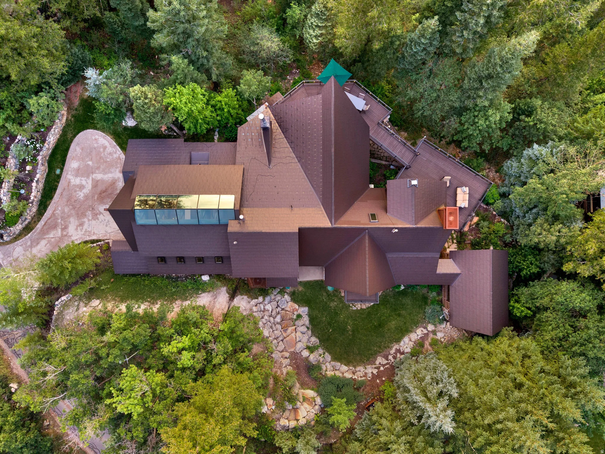 Multi-level residential structure with a brown shingled roof and integrated skylight feature