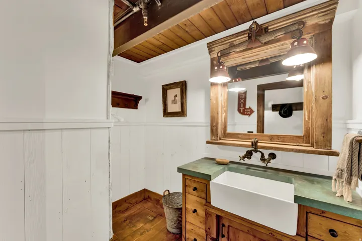 Elegant primary bathroom showcasing shiplap wainscoting, wood-finish vanity with dual vessel sinks, green quartz countertop, and oil-rubbed bronze faucetry