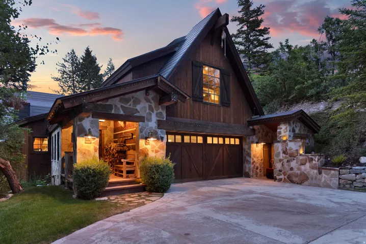 Contemporary mountain residence showcasing a striking A-frame architectural design with mixed-material exterior combining dark wood siding and stacked stone