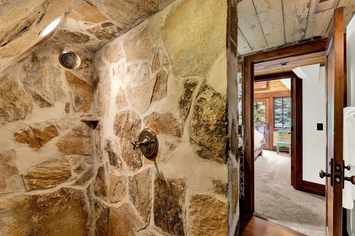 Rustic stone accent wall featuring natural earth-toned masonry with bronze hardware fixtures