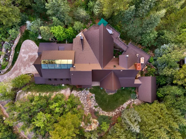 Multi-level residential structure with a brown shingled roof and integrated skylight feature