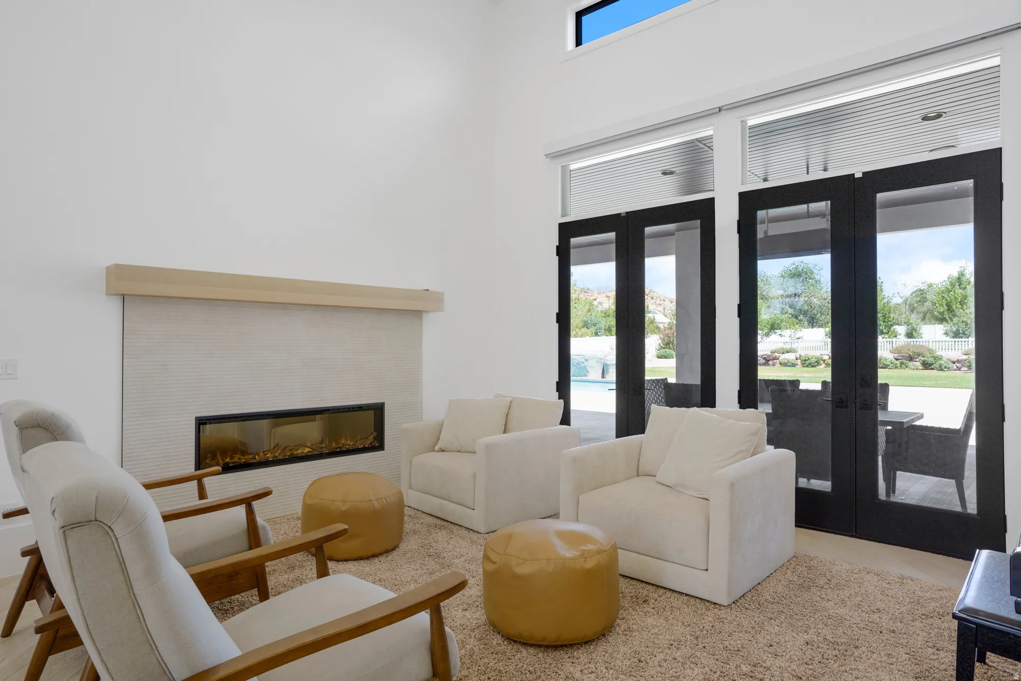 Spacious interior featuring a contemporary fireplace with a light-toned wood mantel and textured tile surround