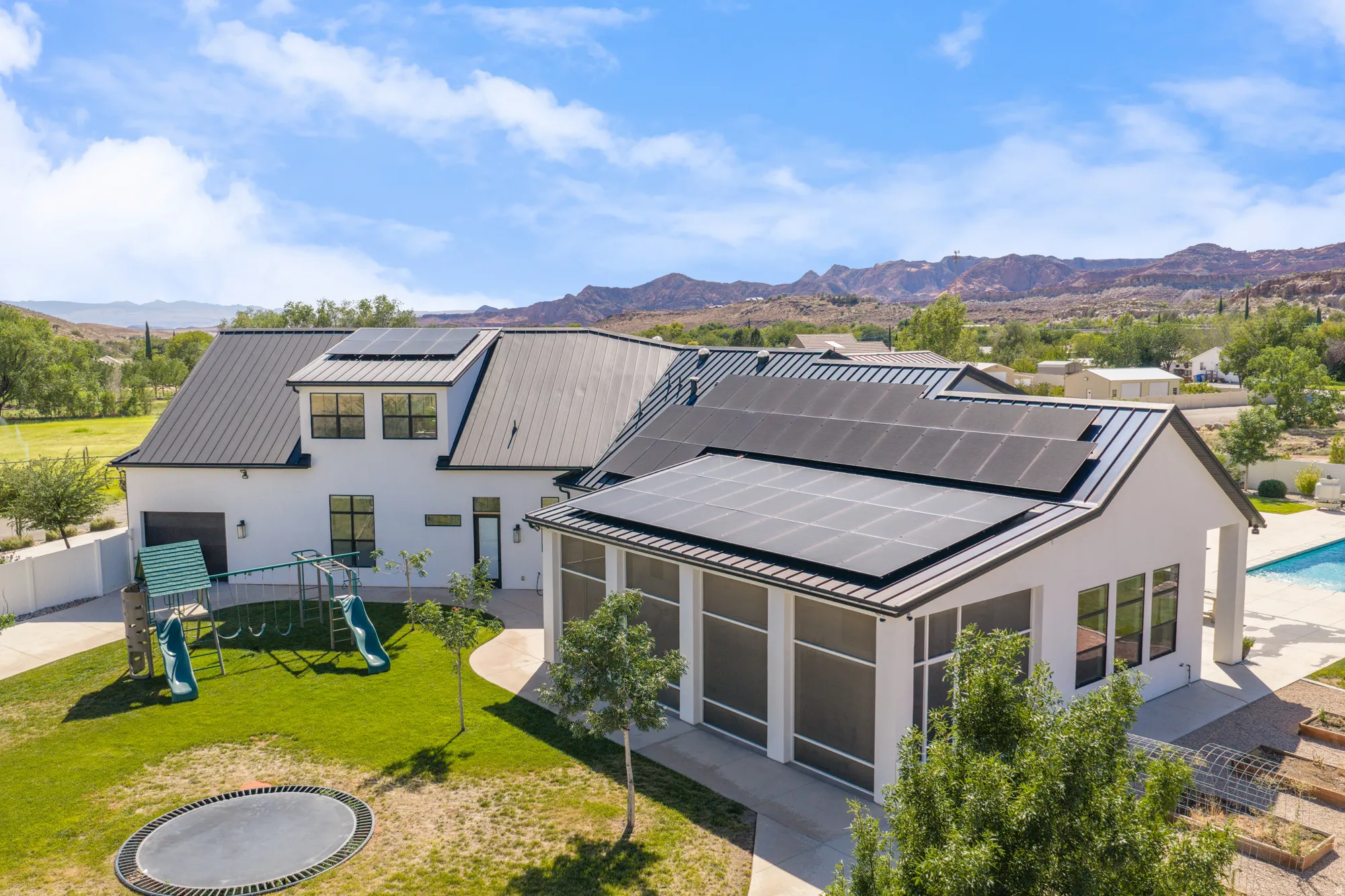 Modern farmhouse estate showcasing a sophisticated two-structure design with clean-lined architecture, standing-seam metal roofing, and expansive glass fenestration