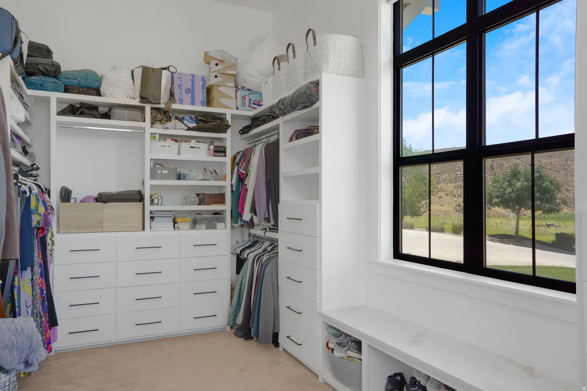 Custom closet system featuring extensive built-in cabinetry, shelving, and hanging rods