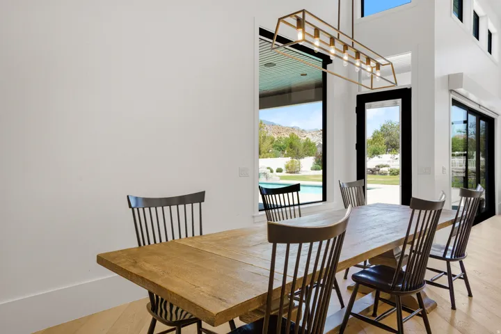 Dining room featuring a wood-finish dining table with seating for six, complemented by spindle-back chairs