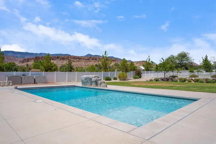 Rectangular inground swimming pool with integrated spa, surrounded by a concrete deck