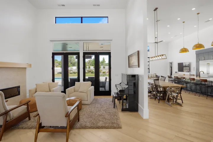 Great room with high ceilings, featuring a fireplace with a stone surround and wood mantel