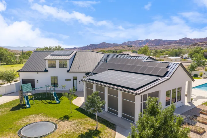 Modern farmhouse estate showcasing a sophisticated two-structure design with clean-lined architecture, standing-seam metal roofing, and expansive glass fenestration