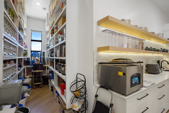 Specialized laboratory workspace featuring custom built-in cabinetry with extensive shelving, stainless steel work surfaces, and integrated scientific equipment including a thermal imaging camera and precision instruments