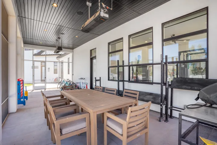 Covered patio featuring a slatted dark ceiling with recessed lighting and mounted heaters