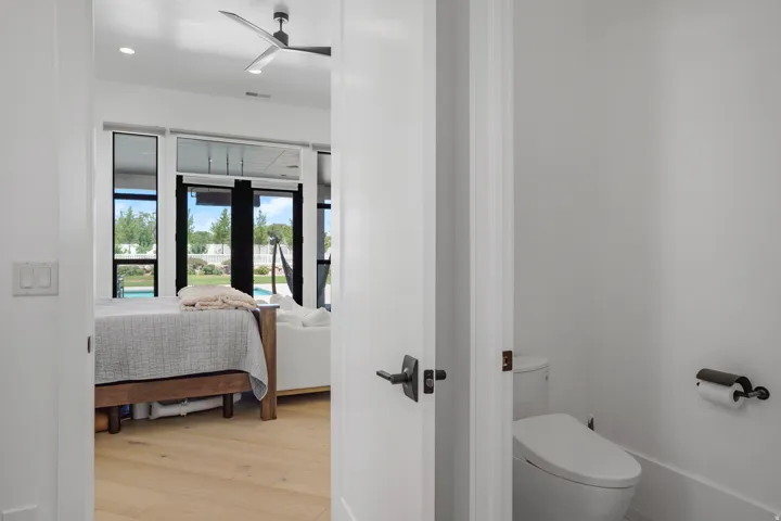 Spacious room featuring wood-finish flooring and large windows with black framing