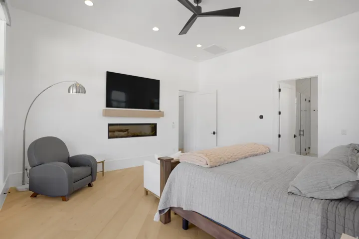 Spacious primary bedroom featuring hardwood flooring, a ceiling fan, and recessed lighting throughout