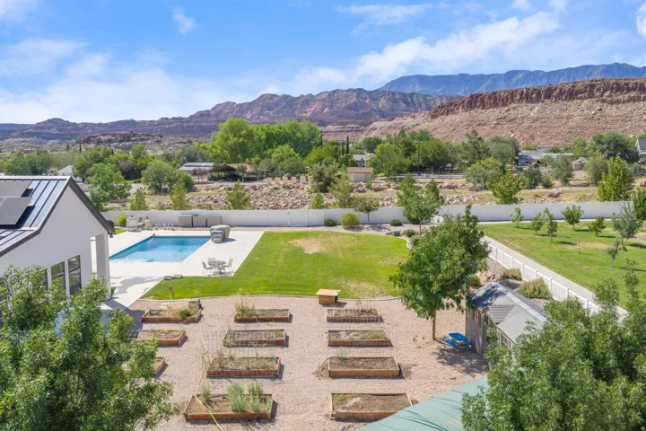 Expansive outdoor living area featuring a rectangular swimming pool, integrated spa, and surrounding concrete patio