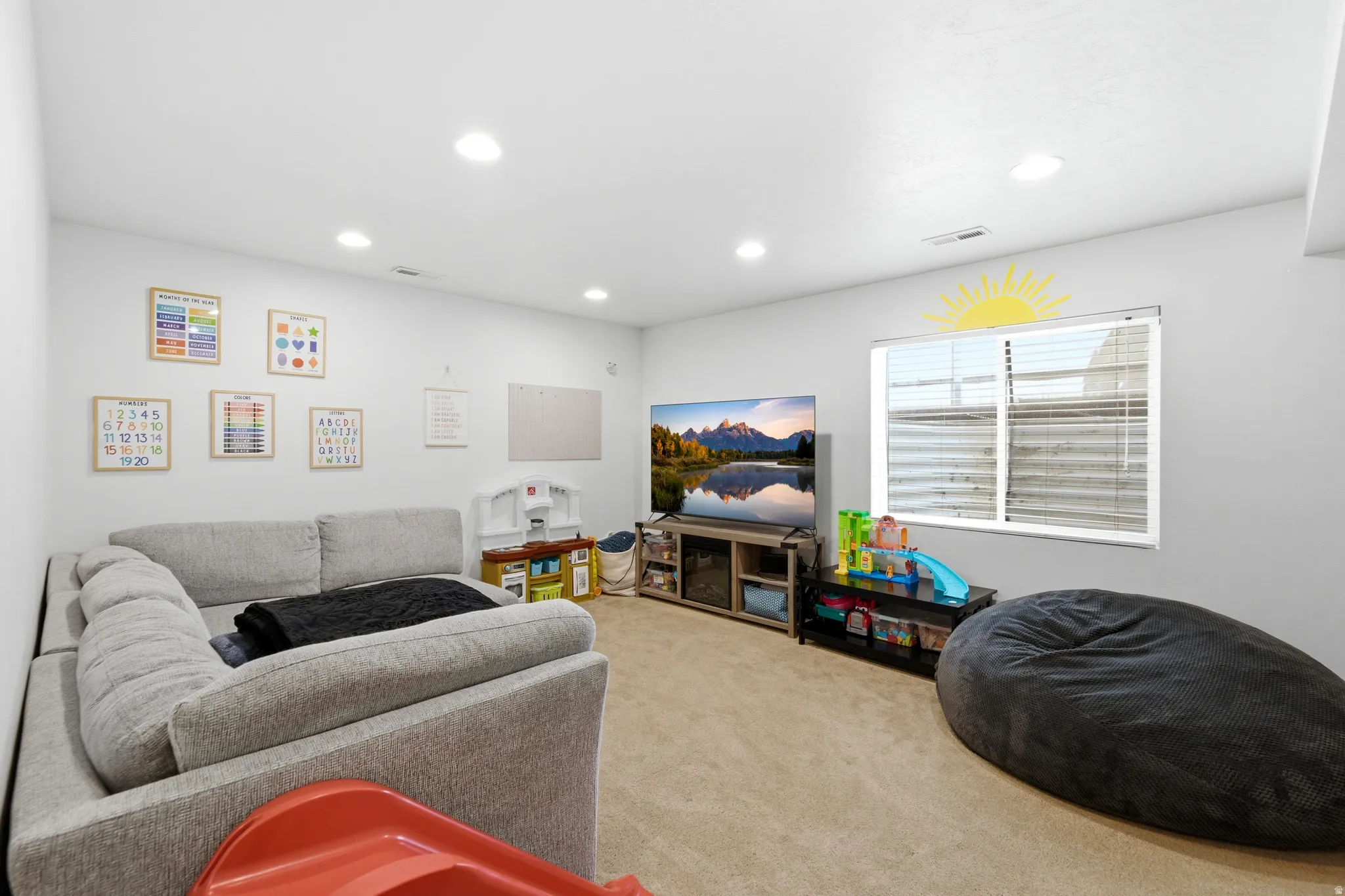 Carpeted room featuring recessed lighting, a single window with horizontal blinds, and light-toned walls