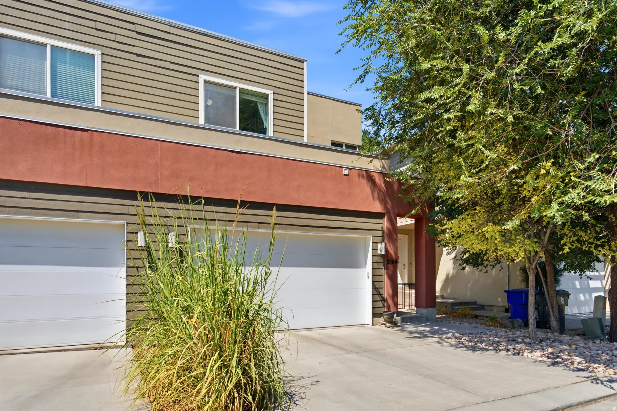 Modern two-story residence featuring a clean-lined façade with horizontal siding, metal accent trim, and contemporary architectural details