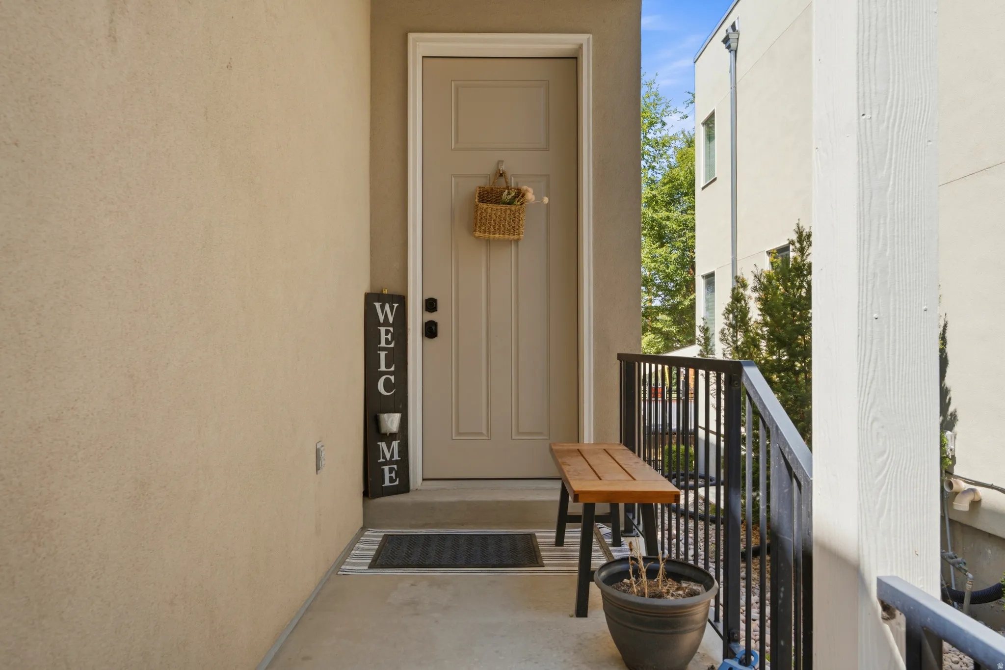 Entryway featuring a beige paneled door, black hardware, and stucco exterior