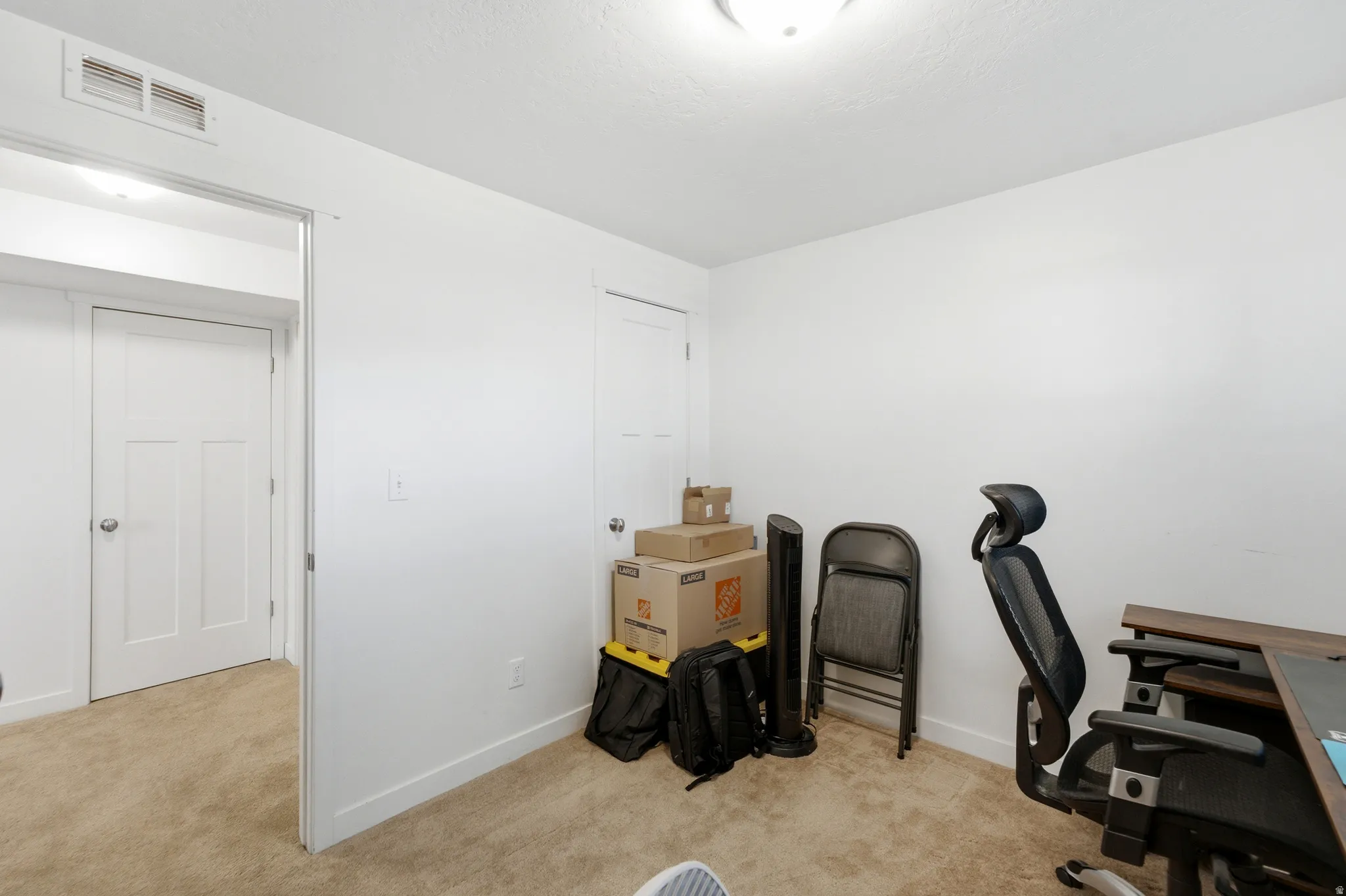 Versatile bonus room with neutral carpet flooring, white painted walls, and multiple entry points