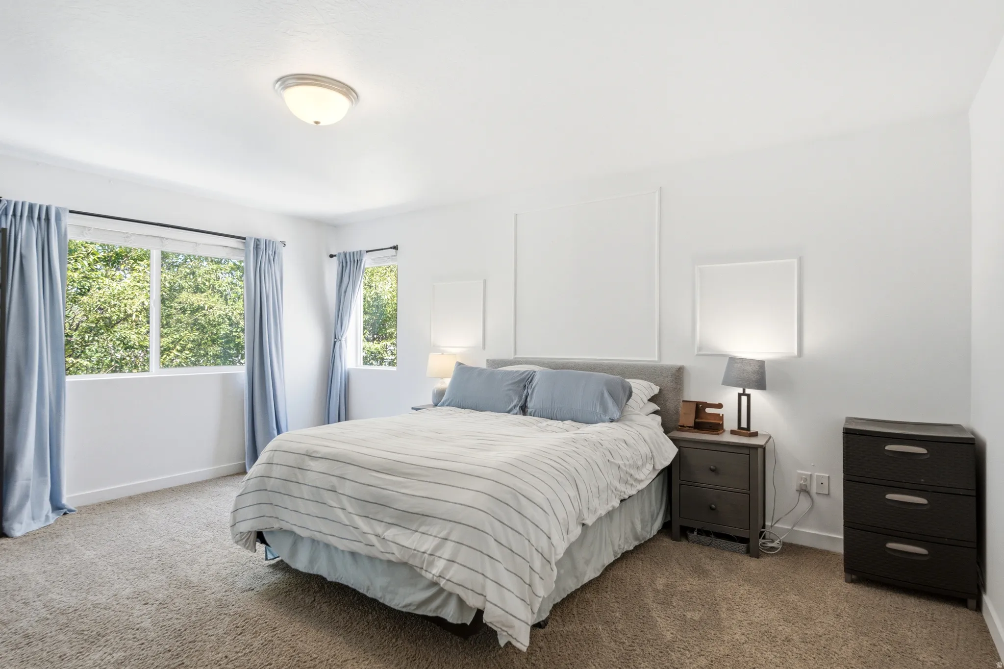 Room featuring light-colored carpeting, white walls, and a ceiling-mounted light fixture